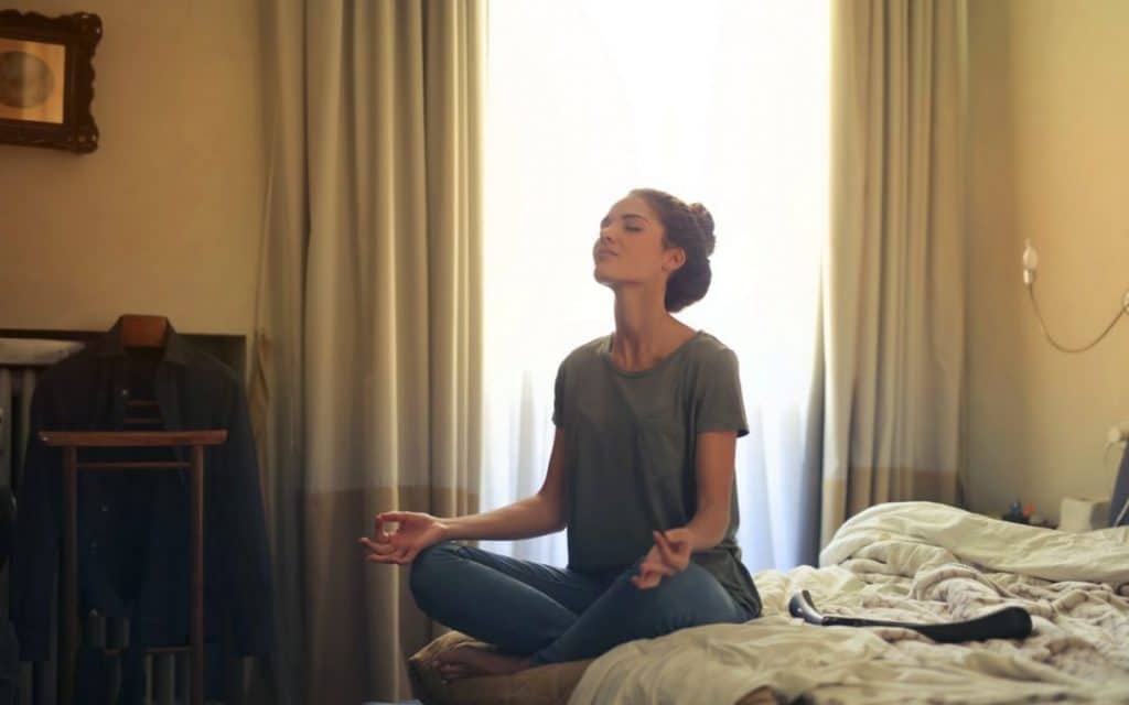 woman meditating in bedroom